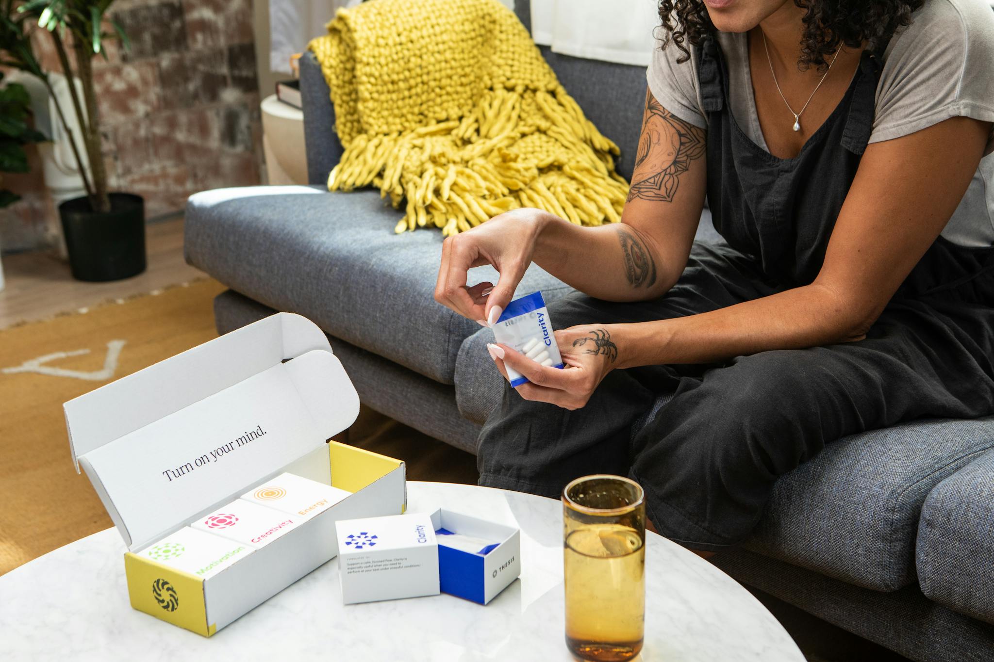 A woman sitting on a sofa examining nootropic supplements, promoting wellness and clarity.