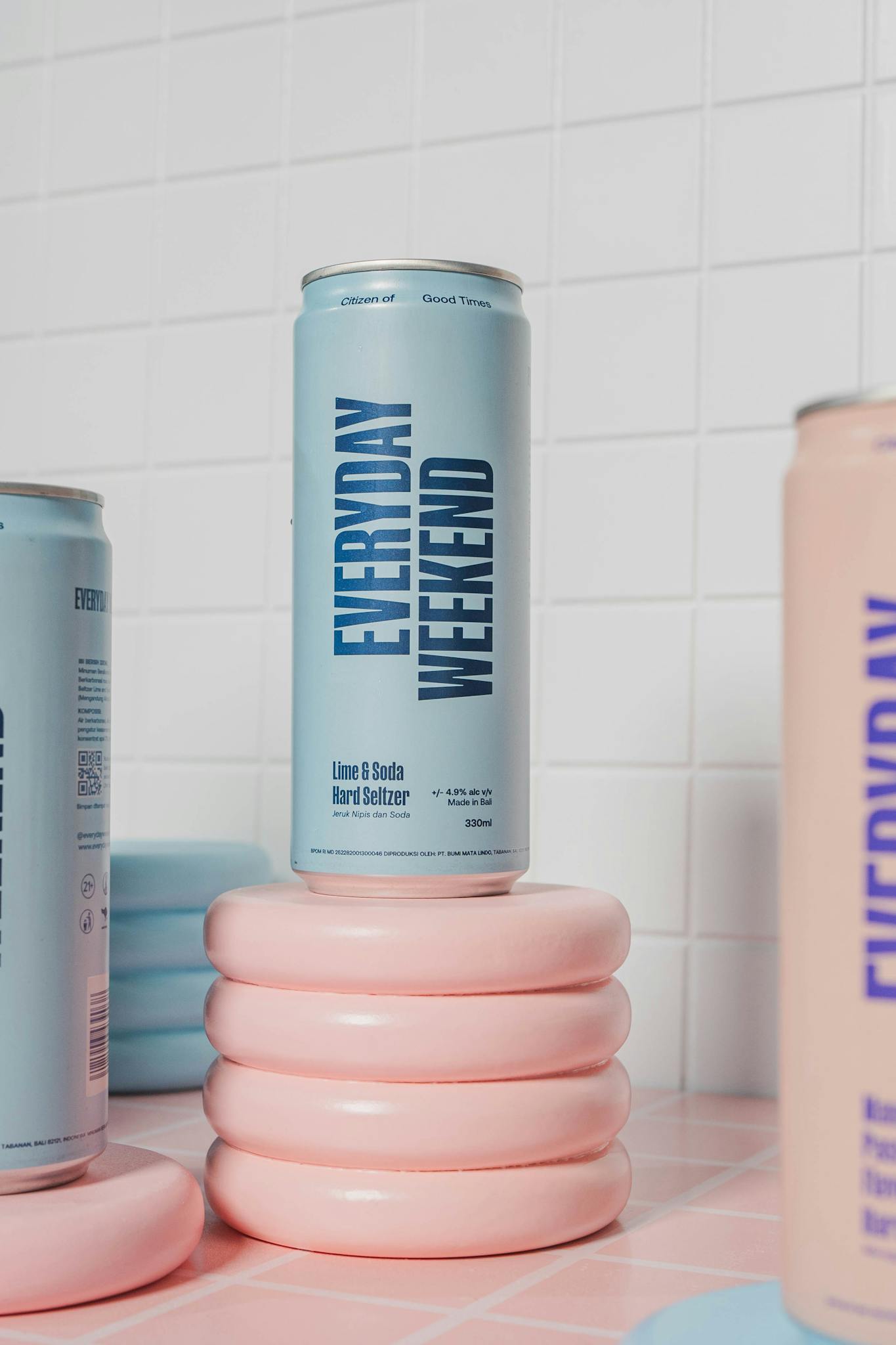 Chic lime and soda hard seltzer cans on pastel surfaces, stylishly arranged for modern aesthetics.