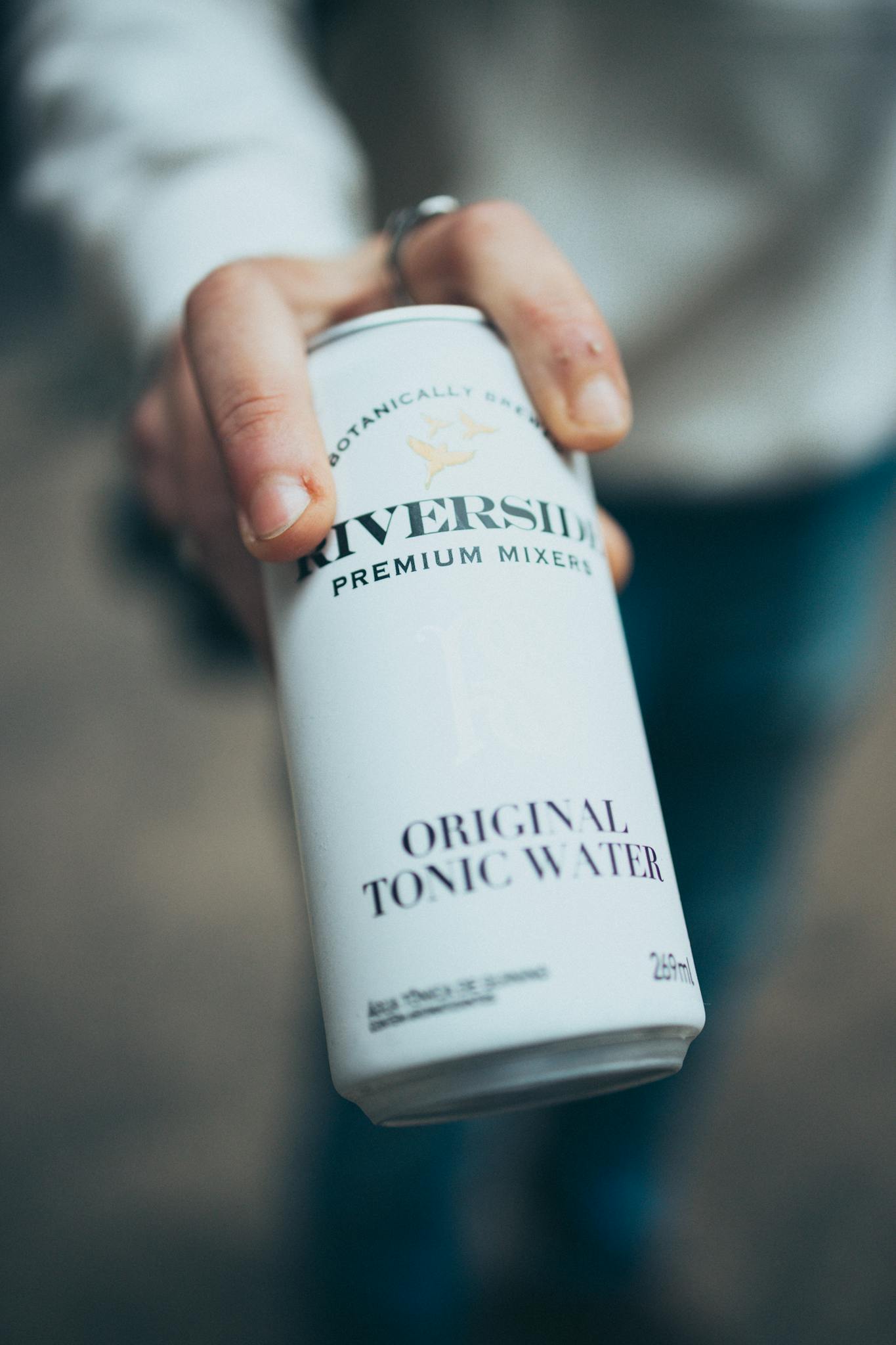 Close-up of a hand holding a can of premium tonic water, ideal for refreshment scenes.